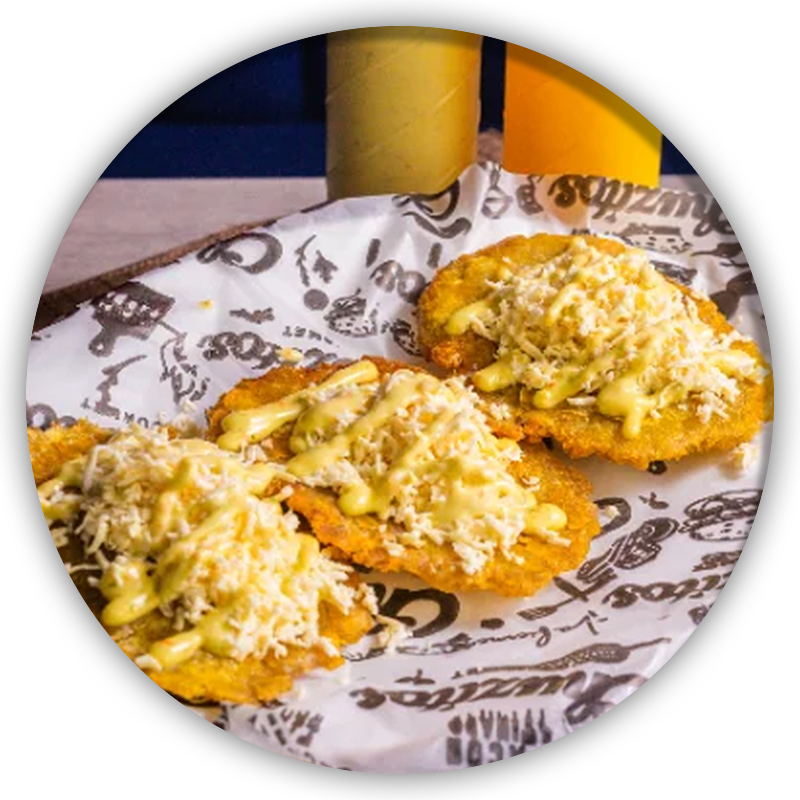 Patacones con queso rallado y salsa de ajo